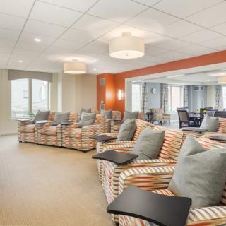 A modern seating area with striped chairs and ample lighting.