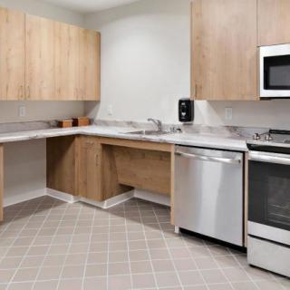 A modern kitchen with wooden cabinets and stainless steel appliances.