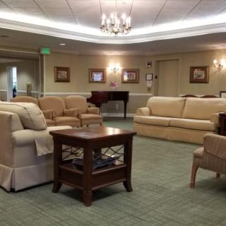 A cozy living room with comfortable sofas, a central coffee table, and a chandelier providing overhead lighting.