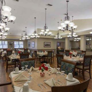 An elegant dining room with neatly arranged tables and chandeliers.