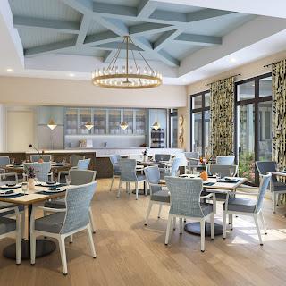 A modern and elegantly designed dining room featuring blue accents and a spacious layout.