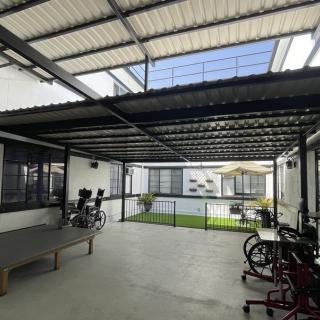 A spacious patio with a metal roof, featuring bicycles and a ping pong table.