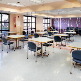 An empty classroom setup with tables and chairs, ready for an educational session.