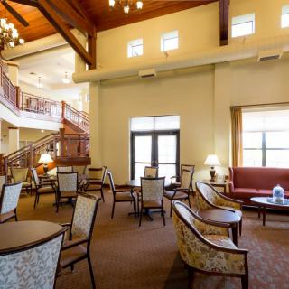 A spacious lobby with elegant seating and a staircase.