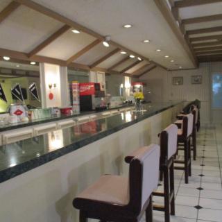 An empty bar with high chairs and a modern interior design.