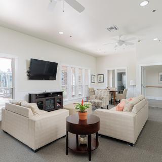A bright and modern living room with comfortable sofas, a television mounted on the wall, and tasteful interior design elements.