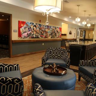 A modern lobby with stylish seating and vibrant artwork on the wall.