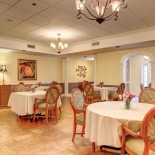 An elegant dining room with beautifully set tables and ornate chandeliers.