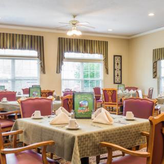 A well-arranged dining area with set tables and comfortable chairs in a light-filled room.