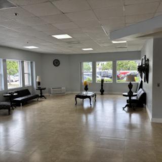 A spacious and modern waiting area featuring comfortable seating, large windows for natural light, and a minimalist decor.