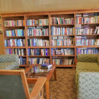 A cozy reading area with bookshelves filled with books and comfortable seating.