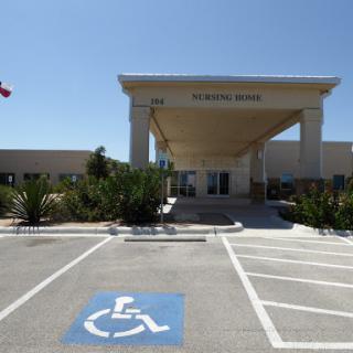 A welcoming entrance with designated handicap parking, set against a clear blue sky.