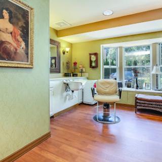 A cozy hair salon featuring stylish decor and a comfortable seating area.