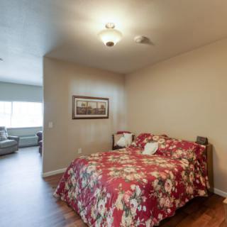 A cozy bedroom with a floral bedspread and warm lighting.
