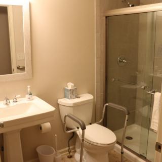 Accessible bathroom with a toilet, sink, and shower.