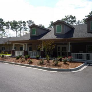 A residential building with a landscaped front yard and driveway.