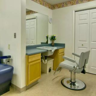 A hair salon interior with a styling chair and mirror.