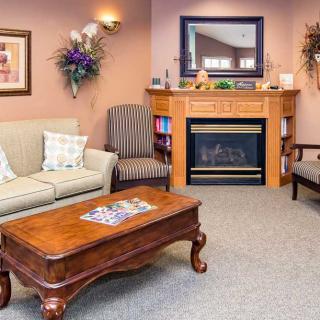 A cozy living room with a sofa, coffee table, and fireplace.
