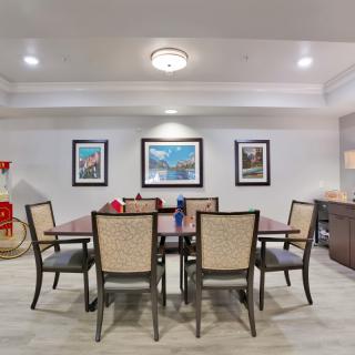 A modern dining room featuring a large table surrounded by chairs and adorned with artwork on the walls.