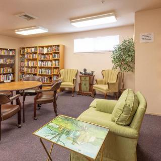 A cozy library reading room with bookshelves and comfortable seating.