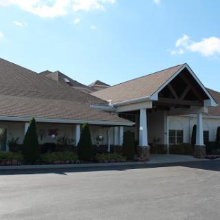 A welcoming commercial building with a landscaped entrance and clear blue skies.