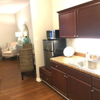 A modern apartment kitchen and living area with warm lighting.