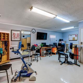 A physical therapy room equipped with various exercise and rehabilitation machines.