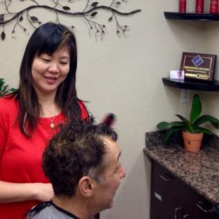 A stylist giving a haircut to a customer in a salon.