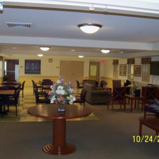 Spacious lounge area with tables, chairs, and soft lighting.