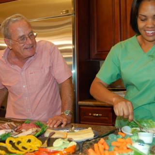 Two people preparing a variety of fresh vegetables in the kitchen.