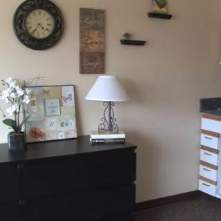 A cozy room with a dresser, lamp, and decorative items.