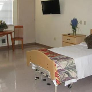 A clean and tidy hospital room with a bed, television, and minimal furnishings.