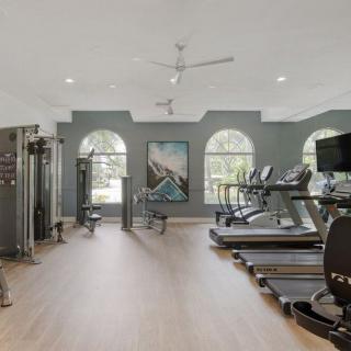 A modern gym with various workout equipment and treadmills.