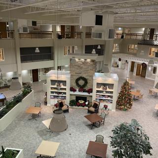 A spacious atrium with festive decorations, including a Christmas tree and seating areas.