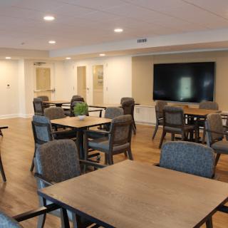 A modern dining and meeting area featuring wooden tables and comfortable chairs, designed for community gatherings.