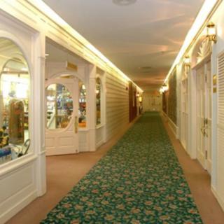 A well-lit hallway with a patterned carpet and decorative arches.