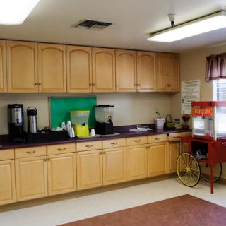 Spacious kitchen area with cabinets, a popcorn machine, and coffee station.