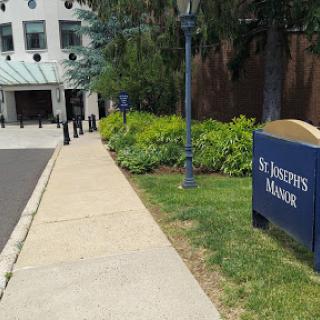 A view of St. Joseph's Manor, showcasing the entrance and well-maintained landscaping.