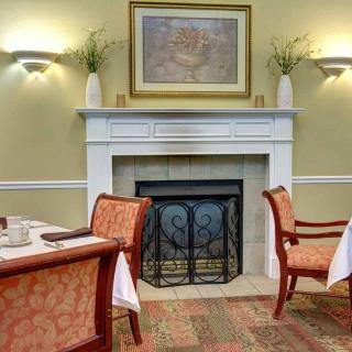 A cozy dining area featuring an elegant fireplace and well-set tables.