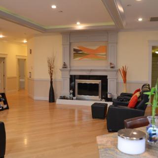 A modern living room featuring a central fireplace, hardwood floors, and contemporary decor.