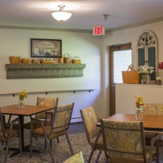 A cozy dining area with tables, chairs, and decorative elements on the walls.
