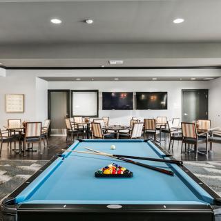 A modern game room featuring a billiards table and seating area.