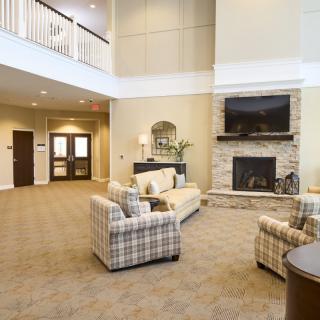 A cozy living room with a fireplace, comfortable seating, and elegant decor.