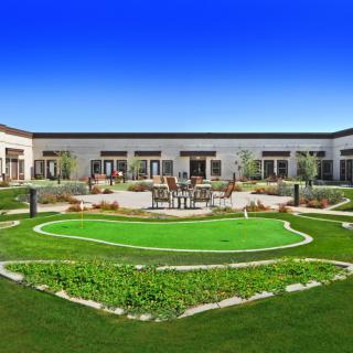 A well-maintained courtyard featuring a green lawn and modern landscaping.