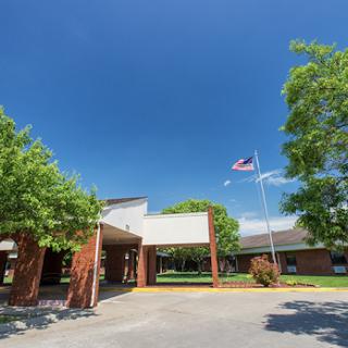 A sunny day at a school building with an American flag waving in the breeze.