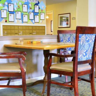 A cozy seating area in a lobby with a wooden table and upholstered chairs.