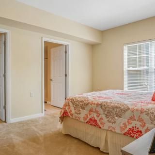 A cozy bedroom with a neatly made bed and light-colored walls.