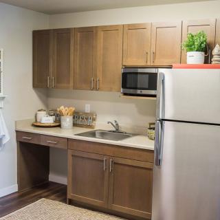 A modern kitchen with wooden cabinets and stainless steel appliances.
