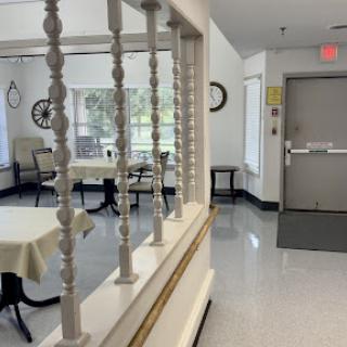 A bright and inviting dining area with tables set for meals, featuring a doorway leading to another space.