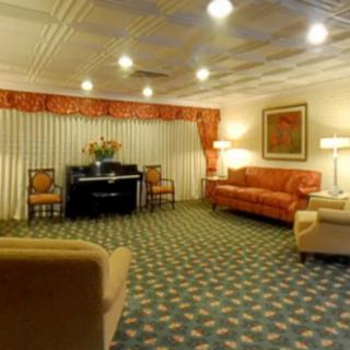 A spacious hotel lounge area with comfortable seating, warm lighting, and classic decor.